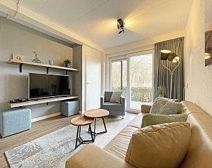 Stilvolles Wohnzimmer des Appartements Bos en Duin 14, Texel, mit Flachbildfernseher und Zugang zur Terrasse.