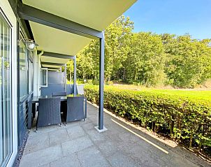 Gerumige Terrasse des Appartements Bos en Duin 14, Texel, mit Sitzgelegenheiten und Blick auf die grne Umgebung.