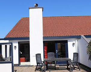 Auenbereich des Ferienhauses Gortersmient 312, De Dennen, Texel, mit groer Veranda und Gartenmbeln.