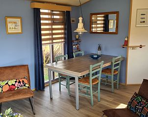 Essecke im Ferienhaus im Vakantiepark De Bremakker, Texel, mit einem rustikalen Tisch und Sthlen.