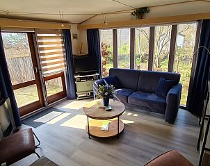 Wohnzimmer im Vakantiepark De Bremakker, Texel, mit bequemen Sitzgelegenheiten und groen Fenstern fr eine tolle Aussicht.