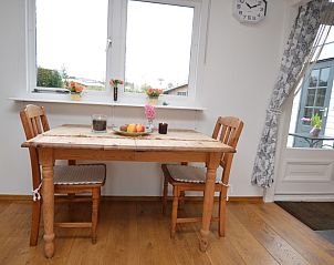 Gemtlicher Essbereich im Bungalow Uterste Coogh 122, Texel, mit Holzmbeln und natrlichem Licht.