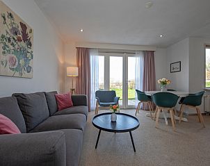 Gezellige woonkamer van Huisje 6 in De Dennen, Texel, met comfortabele zitruimte en uitzicht op de tuin.