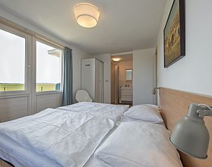 Ruime slaapkamer in Huisje 6, Texel met tweepersoonsbed en prachtig uitzicht op de natuur.