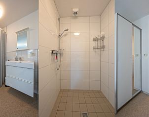 Moderne badkamer in Huisje 6, De Dennen, Texel met douche en wastafel. Praktisch en stijlvol ingericht.