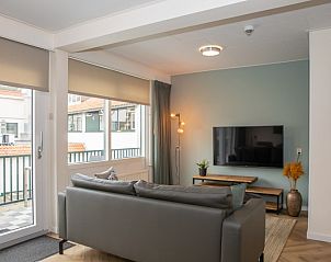 Stilvolles Wohnzimmer mit TV und Balkon im Apartment Bos en Duin 28, De Dennen, Texel.