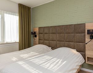 Schlafzimmer im Apartment Bos en Duin 28, De Dennen, Texel mit TV und Kunst an der Wand.