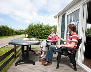 Genieen Sie die Terrasse des Ferienhauses Villetta fr 6 Personen, De Dennen, Texel mit Blick auf die grne Umgebung.