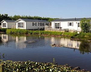 Villetta 4 persoons vakantiehuis aan het water in De Dennen, Texel, met serene vijver en groene omgeving voor ontspanning.