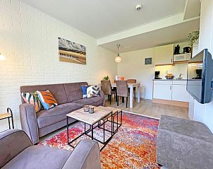 Offenes Wohnzimmer und Kche im Appartement Bos en Duin 31, De Dennen, Texel mit stilvollen Mbeln und buntem Teppich.