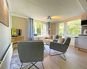 Das gerumige Wohnzimmer mit groen Fenstern im Apartment Bos en Duin 22, De Dennen, Texel, bietet eine tolle Aussicht.