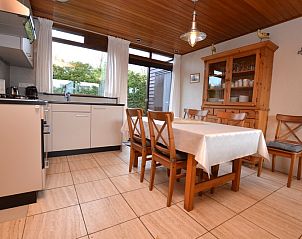 Essecke im Ferienhaus de Parel 258, De Dennen, Texel, mit Holztisch und Sthlen, angrenzend an die Kche.