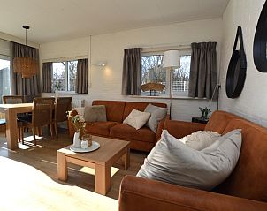 Lichte woonkamer van Bungalow Uterste Coogh 96 in De Dennen, Texel, met comfortabele banken en eethoek op de Waddeneilanden.