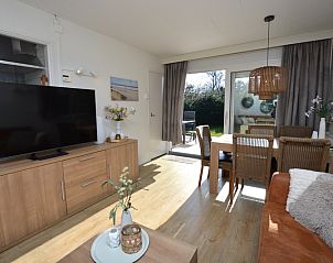 Gezellige zithoek in Bungalow Uterste Coogh 96, De Dennen, Texel, met uitzicht op de tuin en veel natuurlijk licht.