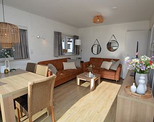 Stijlvolle binnenruimte van Bungalow Uterste Coogh 96 in De Dennen, Texel, met eethoek en gezellige zithoek.