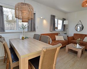 Eethoek in Bungalow Uterste Coogh 96, De Dennen, Texel, met uitzicht op de tuin, perfect voor familiediners.