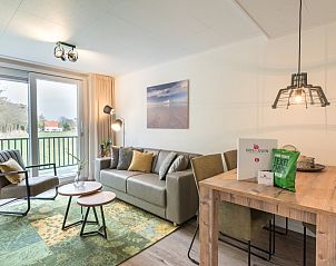 Gezellige woonkamer in Appartement Bos en Duin 32, De Dennen, Texel met comfortabele zithoek en uitzicht op de natuur.