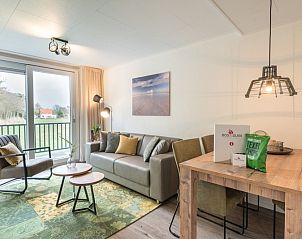 Stijlvol ingerichte woonkamer van Appartement Bos en Duin 32, De Dennen, Texel met moderne meubels en veel lichtinval.
