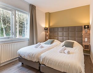 Slaapkamer in Appartement Bos en Duin 32, De Dennen, Texel met comfortabele bedden en uitzicht op de omringende natuur.