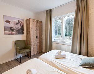 Ruime slaapkamer in Appartement Bos en Duin 32, De Dennen, Texel met grote ramen en rustgevend uitzicht.