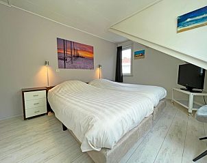 Slaapkamer met moderne inrichting in Appartement Bos en Duin 23, Texel, biedt een rustige plek om te ontspannen.