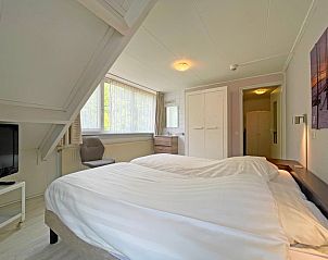 Gezellige binnenruimte van Appartement Bos en Duin 23, De Dennen, Texel, met veel lichtinval en uitzicht op de natuur.