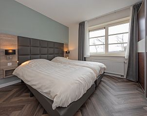 Komfortables Schlafzimmer im Apartment Bos en Duin 37, De Dennen, Texel, mit groem Fenster und moderner Einrichtung.