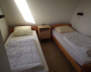 Tweepersoonsbedden in knusse slaapkamer van Vakantiehuis Gortersmient 210, De Dennen, Texel.