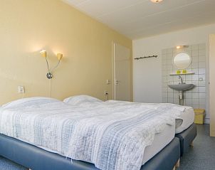 Slaapkamer in vakantiehuis Peter, De Dennen, Texel met tweepersoonsbed en zachte verlichting.