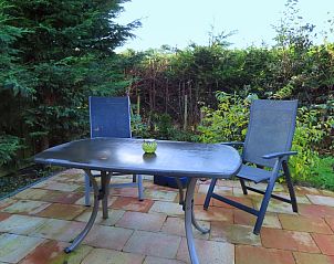 Gemtliche Terrasse im Ferienhaus Dunkonijn in De Dennen Texel, umgeben von grner Natur.