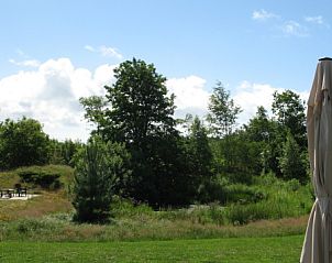 Genieen Sie die grne Aussicht im Vijverhof 6-Personen-Ferienhaus in De Dennen, Texel, umgeben von ppiger Natur und Ruhe.