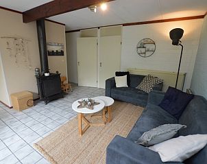 Knusse binnenruimte in Bungalow Verste Coogh 56, De Dennen, Texel, met houtkachel voor gezellige avonden.