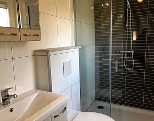Moderne badkamer in Vakantiepark de Bremakker - Bosveld 103, vakantiehuis in De Dennen, Texel, met stijlvolle douche en wastafel.