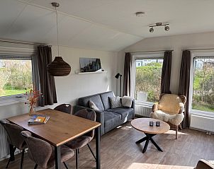 Gemtliches Wohnzimmer im Chalet Skeep im Ferienpark De Bremakker, De Dennen, Texel. Komfortabler Sitzbereich mit Blick auf die Natur.