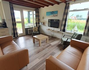 Gezellige woonkamer van Weizicht Texel vakantiehuis in De Dennen, Texel, met moderne inrichting en uitzicht op de groene natuur.