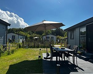 Gerumige Terrasse mit Sonnenschirm im Vakantiepark de Bremakker - Chalet Wulk, De Dennen, Texel, ideal fr Mahlzeiten im Freien.