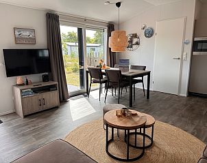 Stilvolles Wohnzimmer des Chalets Wulk im Vakantiepark de Bremakker, Texel, mit moderner Einrichtung und Gartenblick.
