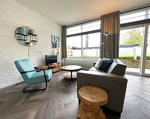 Gemtliche Sitzecke im Apartment Bos en Duin 03, De Dennen, Texel mit bequemem Sessel und Blick auf die Terrasse.