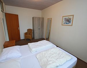 Ruhiges Schlafzimmer im Ferienhaus Carnation, De Dennen, Texel mit Spiegel und Kleiderschrank.