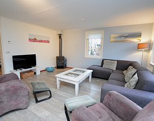 Moderne woonkamer van Vakantiehuis de Parel 214 in De Dennen, Texel, met open haard.