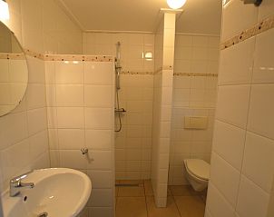 Badkamer van Vakantiehuis de Parel 214 in De Dennen, Texel, met douche en wastafel.