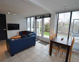Lichte woonkamer in Vakantiehuis de Parel 244, De Dennen, Texel met comfortabele zithoek en eetgedeelte.