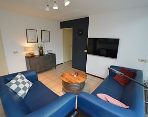 Stijlvolle zithoek in Vakantiehuis de Parel 244, De Dennen, Texel met moderne meubels en tv.