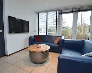 Comfortabele zithoek met tv in Vakantiehuis de Parel 244, De Dennen, Texel, ideaal voor ontspanning.