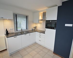 Moderne keuken in Vakantiehuis de Parel 244, De Dennen, Texel met strakke lijnen en apparatuur.