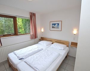 Schlafzimmer mit groem Kleiderschrank im Ferienhaus de Parel 286, De Dennen, Texel mit Blick auf den Garten.