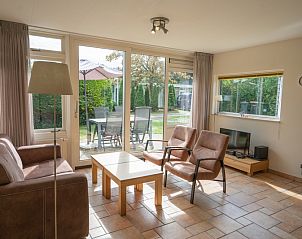 Lichte woonkamer van Bungalow Uterste Coogh 98 in De Dennen, Texel met comfortabele zitruimte en uitzicht op de tuin.