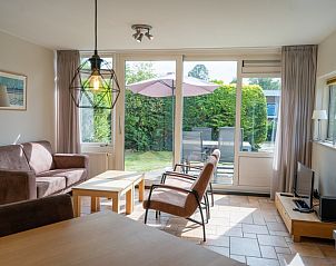 Gezellige binnenruimte van Bungalow Uterste Coogh 98 in De Dennen, Texel met zithoek en toegang tot het terras.