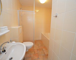 Moderne badkamer in Bungalow Uterste Coogh 98, De Dennen, Texel met douche en ligbad voor ultiem comfort.