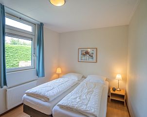 Hoofdslaapkamer in Bungalow Uterste Coogh 98, De Dennen, Texel met twee comfortabele bedden en natuurlijke lichtinval.